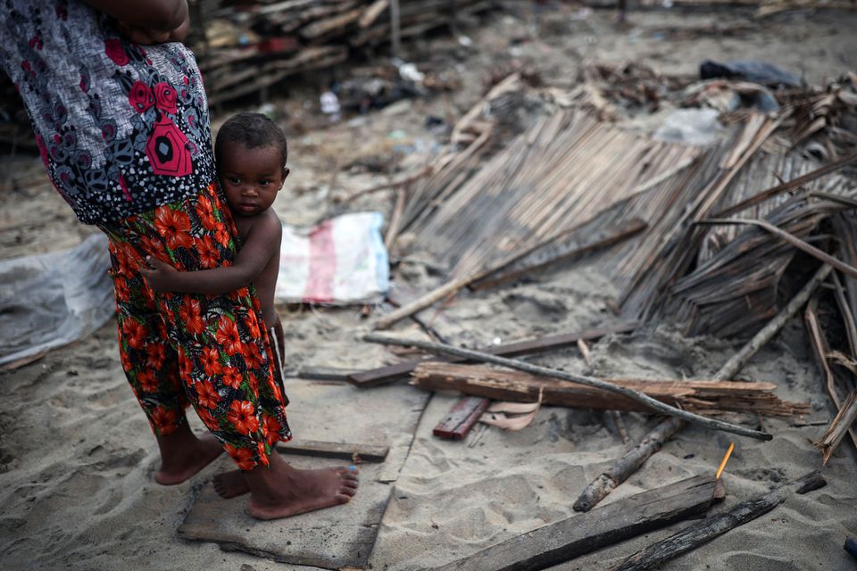 A child holds onto its mother as they stand next to debris, in the aftermath of Cyclone Batsirai, in the town of Mananjary, Madagascar, February 7, 2022. Photo: Reuters