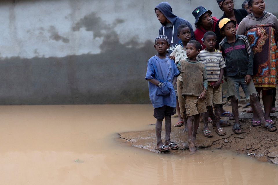 Locals stand next to a flooded area, as Cyclone Batsirai sweeps inland, in Fianarantsoa, Madagascar, February 6, 2022. Photo: Reuters