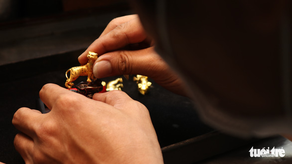 An employee shows a gold tiger statue at a jewelry shop in Ho Chi Minh City. Photo: Cong Trieu / Tuoi Tre