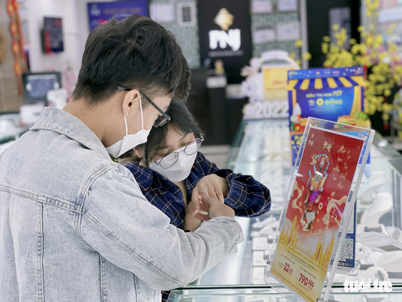 Customers choose gold rings at a jewelry shop in Ho Chi Minh City on February 8, 2022. Photo: Cong Trieu / Tuoi Tre