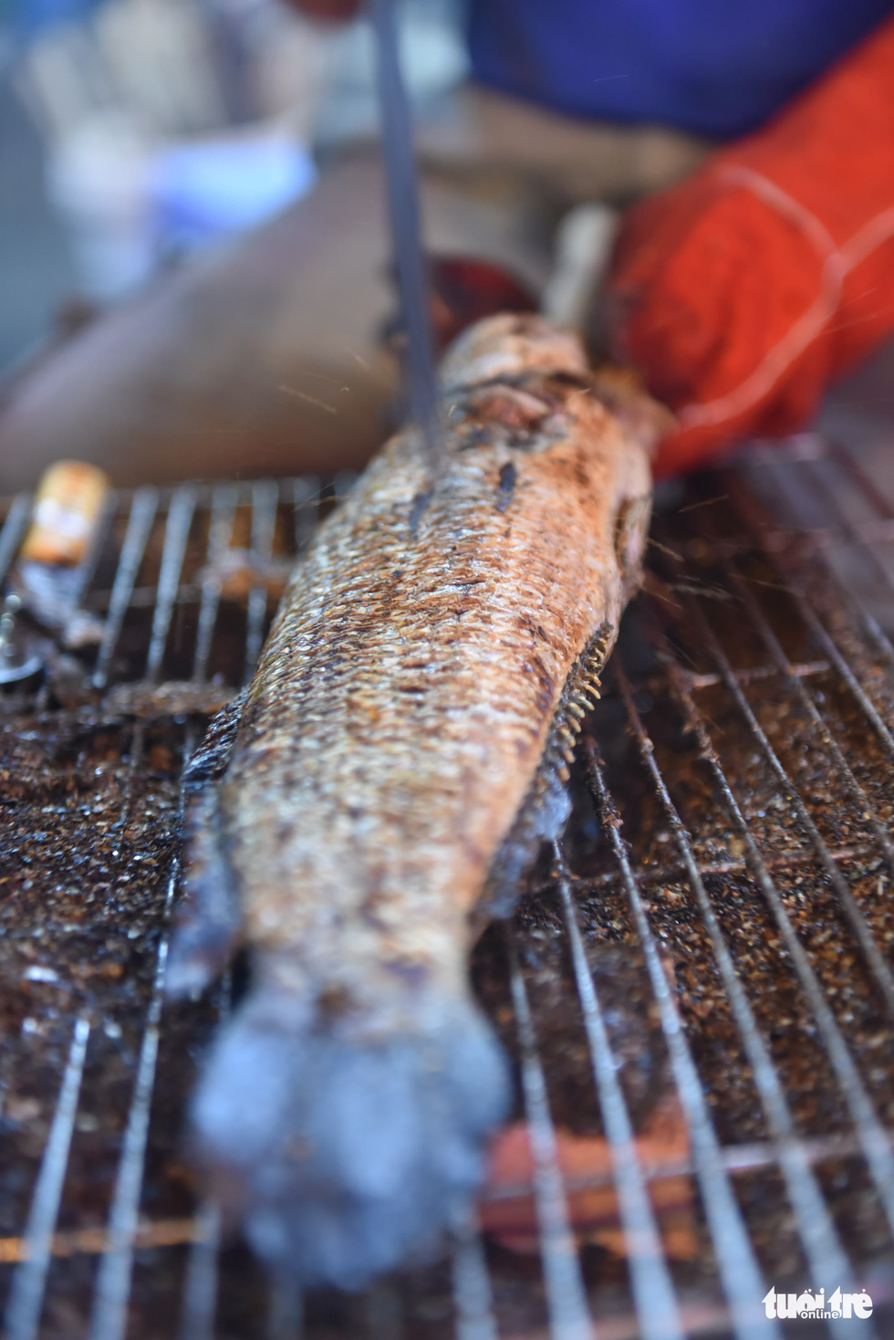 A snakehead fish on the grill at a shop in Tan Phu District, Ho Chi Minh City, February 9, 2022. Photo: Ngoc Phuong / Tuoi Tre