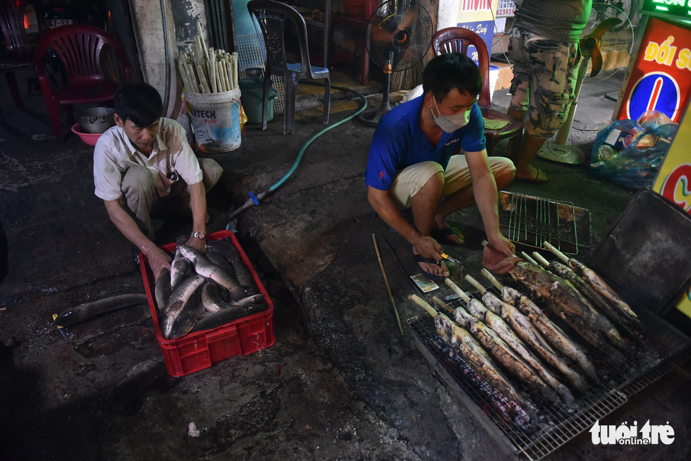 Snakehead fish are skewered on sugarcane before they are grilled at a shop in Tan Phu District, Ho Chi Minh City, February 9, 2022. Photo: Ngoc Phuong / Tuoi Tre