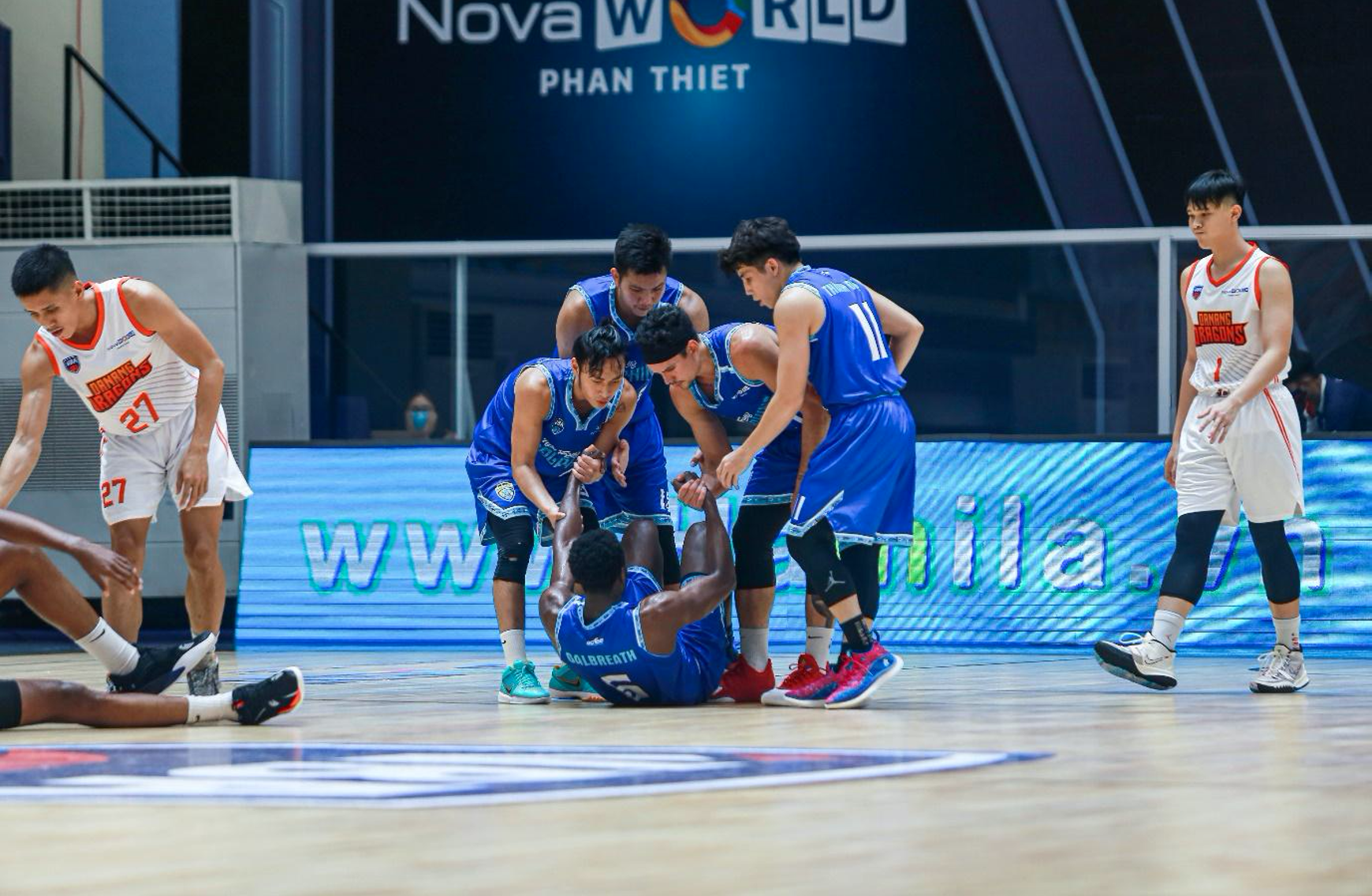 Players of Nha Trang Dolphins help their foreign teammate up following a collision at the VBA Premier Bubble Games. Photo: VBA