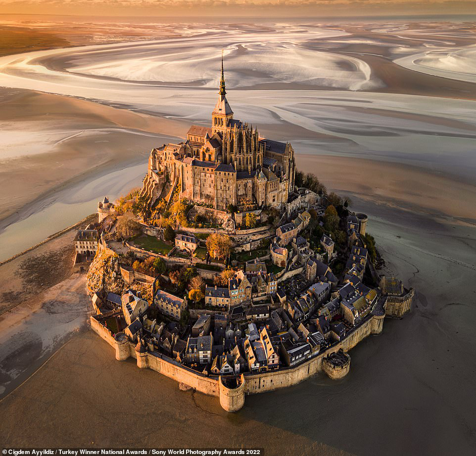 Photographer Cigdem Ayyildiz, who claimed the national award for Turkey, was behind the lens for this enchanting shot, which shows the French commune of Le Mont Saint-Michel at sunset. Ayyildiz says: 'For me, this piece of art on the shores of Normandy is a candidate for Eighth Wonder of the World - providing a legendary view and atmosphere especially at sunset and when the tide is low'. Photo: Sony World Photography Awards 2022