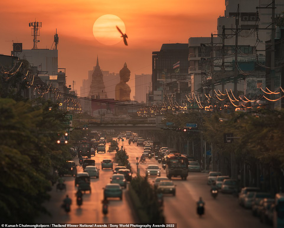 The top prize in the national award for Thailand went to photographer Kunuch Chutmongkolporn, for this beautiful image taken in Bangkok last October. In the background, the Buddha statue from the city's Wat Paknam Bhasicharoen temple can be seen. To get a high-impact shot, Chutmongkolporn used a super-telephoto zoom lens to compress the sun with a bird, the statue, and the city in the foreground. Photo: Sony World Photography Awards 2022