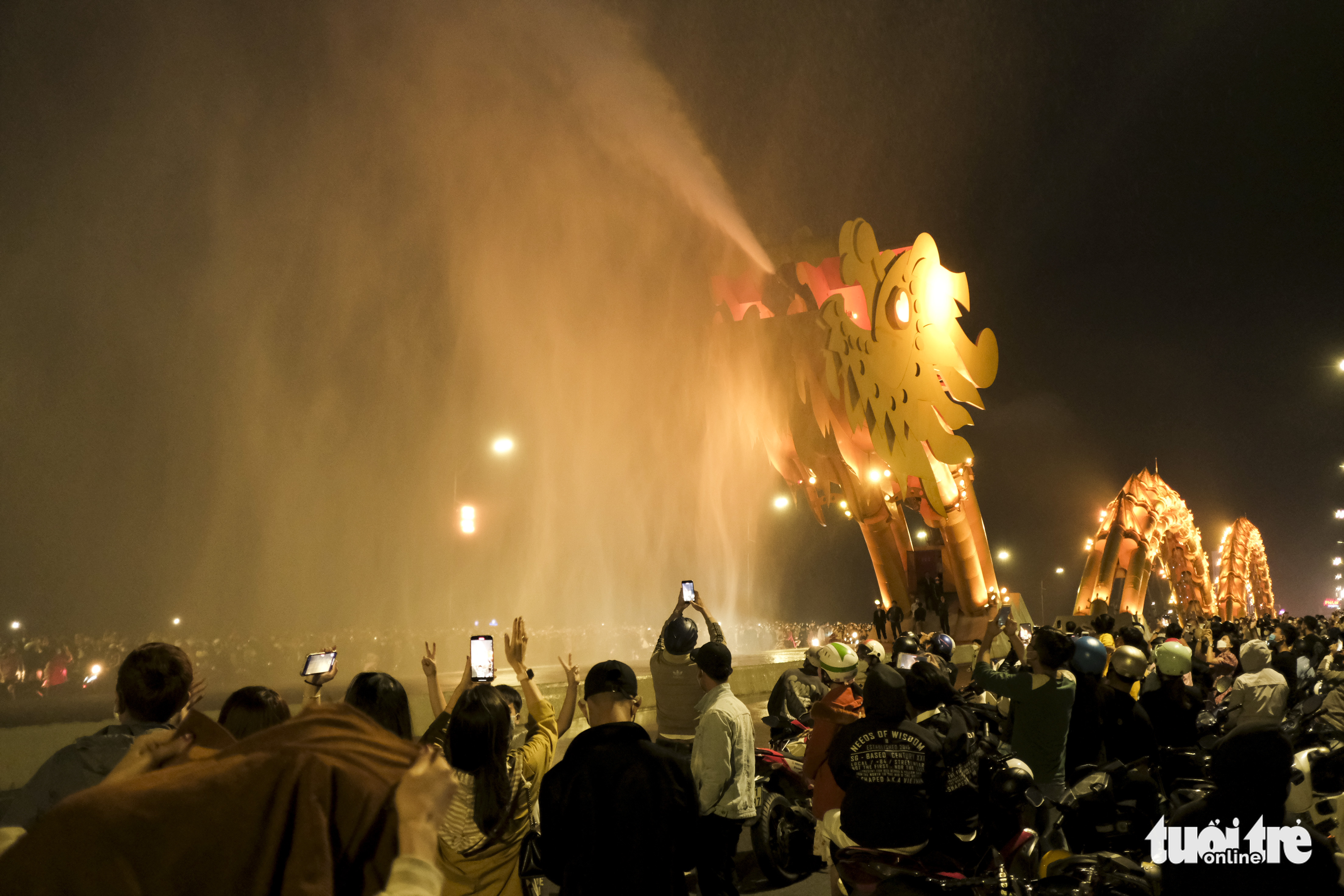 People watch the fire and water breathing show at Dragon Bridge in Da Nang City, Vietnam, February 12, 2022. Photo: Tan Luc / Tuoi Tre