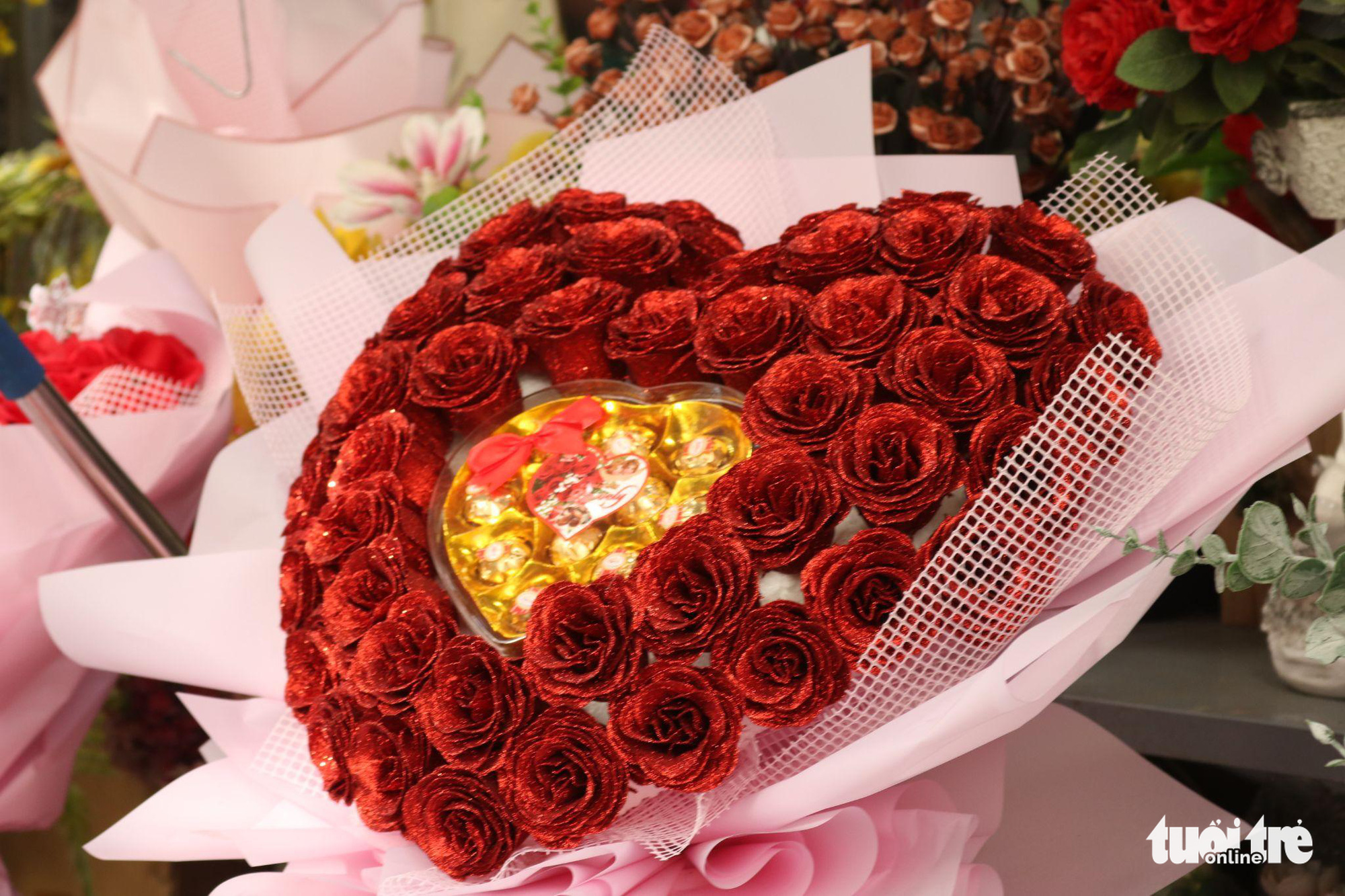 A heart-shaped flower bouquet is attached to a box of chocolate. Photo: Vien Vy / Tuoi Tre