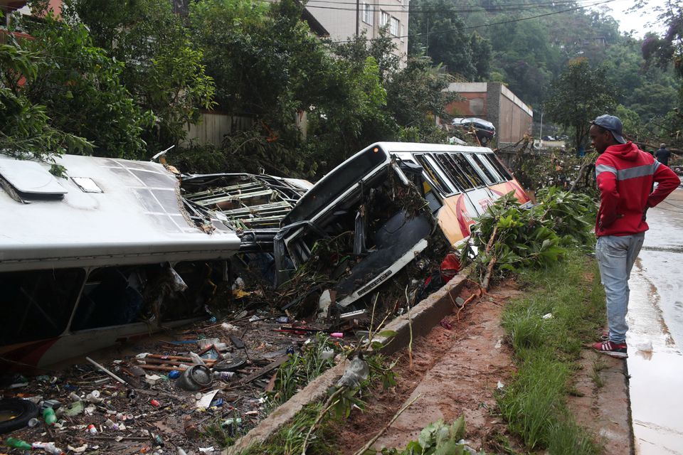 A man observes damaged public buses at a river after pouring rains in Petropolis, Brazil, February 16, 2022. Photo: Reuters
