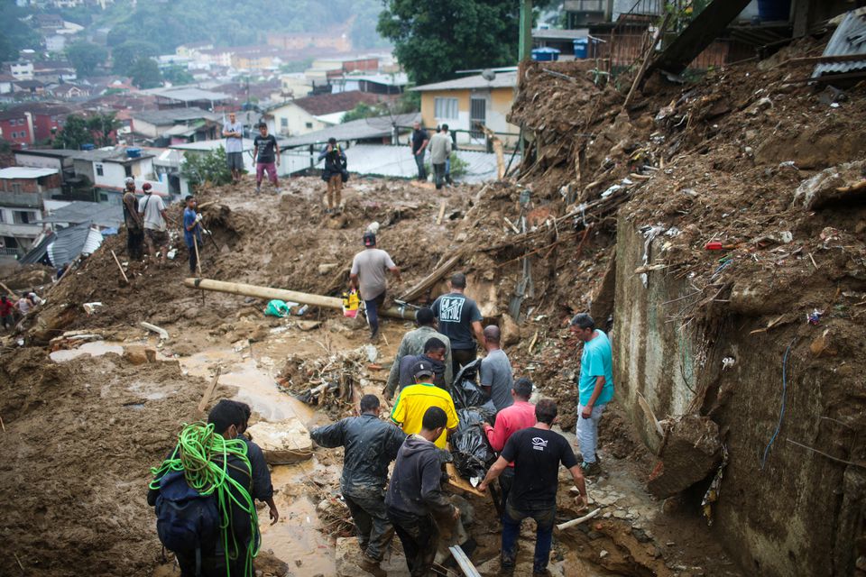 Men carry a body at a mudslide at Morro da Oficina after pouring rains in Petropolis, Brazil February 16, 2022. Photo: Reuters