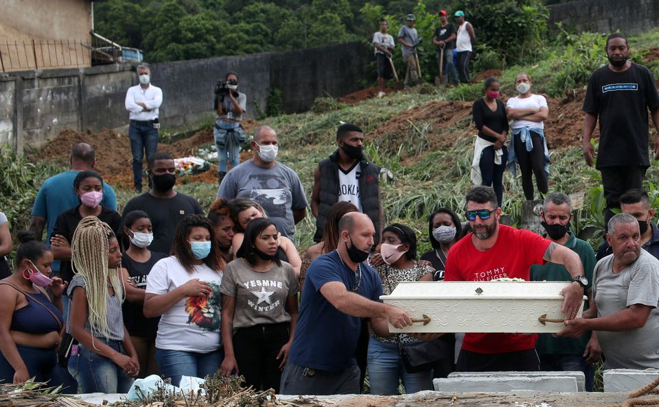 Relatives and friends attend as coffins are carried for the burial of Debora Listenberg, 22 and her kids Heloise, 2 and Gustavo, 5 after pouring rains caused flooding in Petropolis, Brazil February 17, 2022. Photo: Reuters