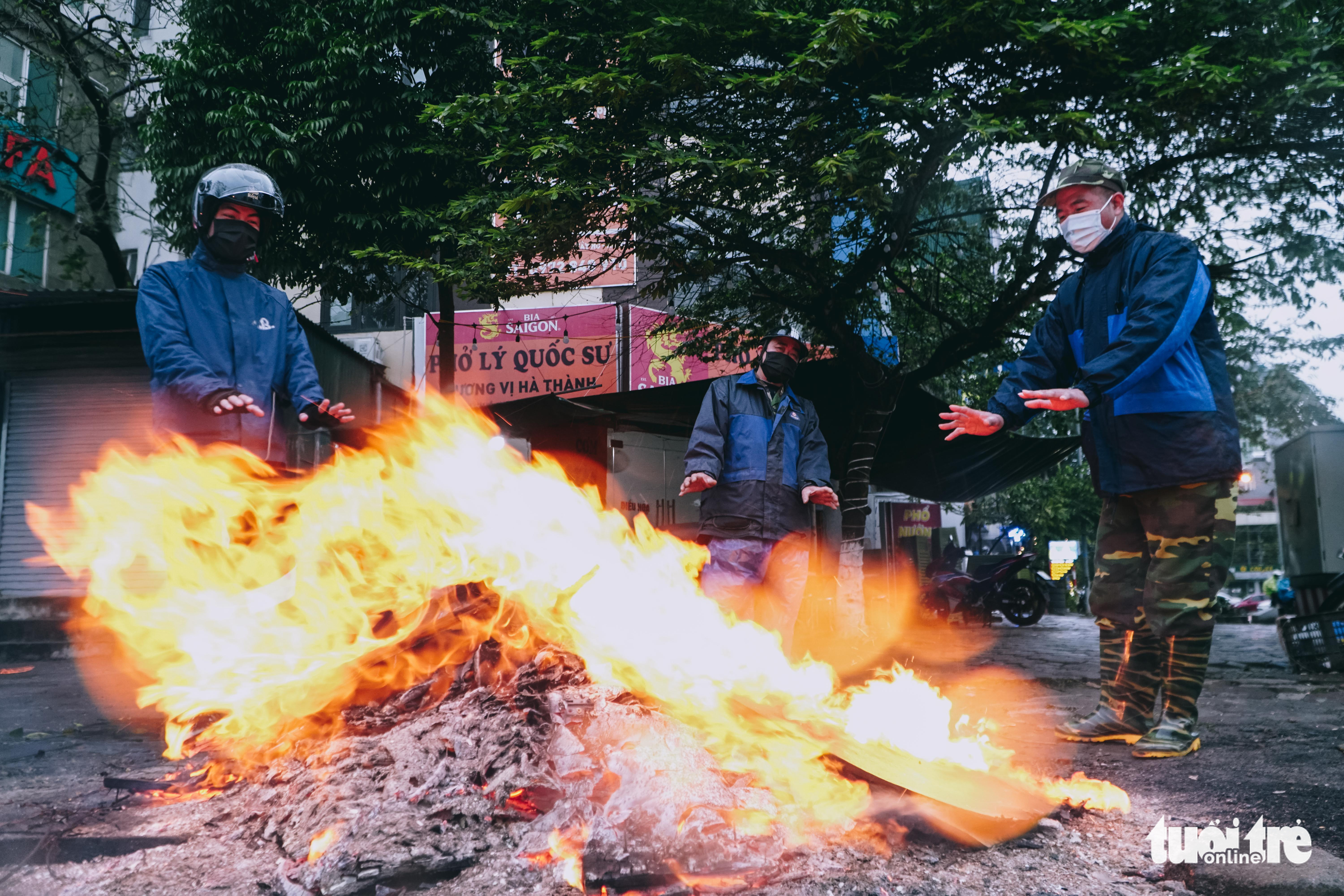 Residents stand by a bonfire on a sidewalk in Hanoi, February 19, 2022. Photo: Pham Tuan / Tuoi Tre