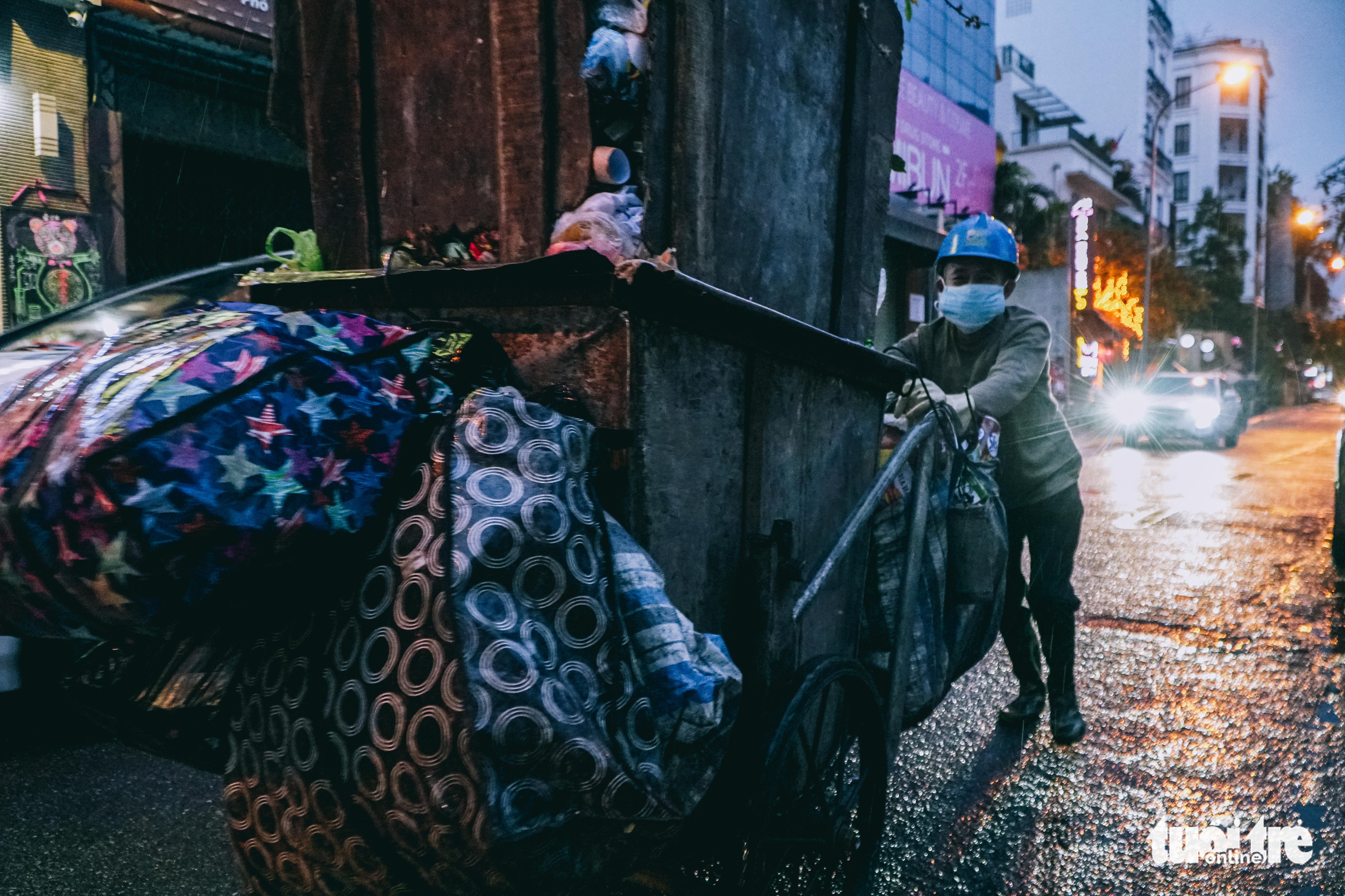 A garbage collector works the cold weather in Hanoi, February 19, 2022. Photo: Pham Tuan / Tuoi Tre