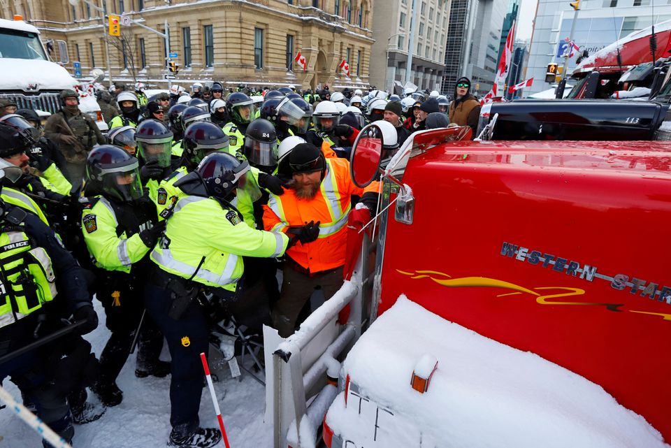 Canadian police push a protestor against a truck in front of Parliament Hill as police work to restore normality to the capital as trucks and demonstrators continue to occupy the downtown core to protest COVID-19 restrictions in Ottawa, Ontario, Canada, February 19, 2022. Photo: Reuters