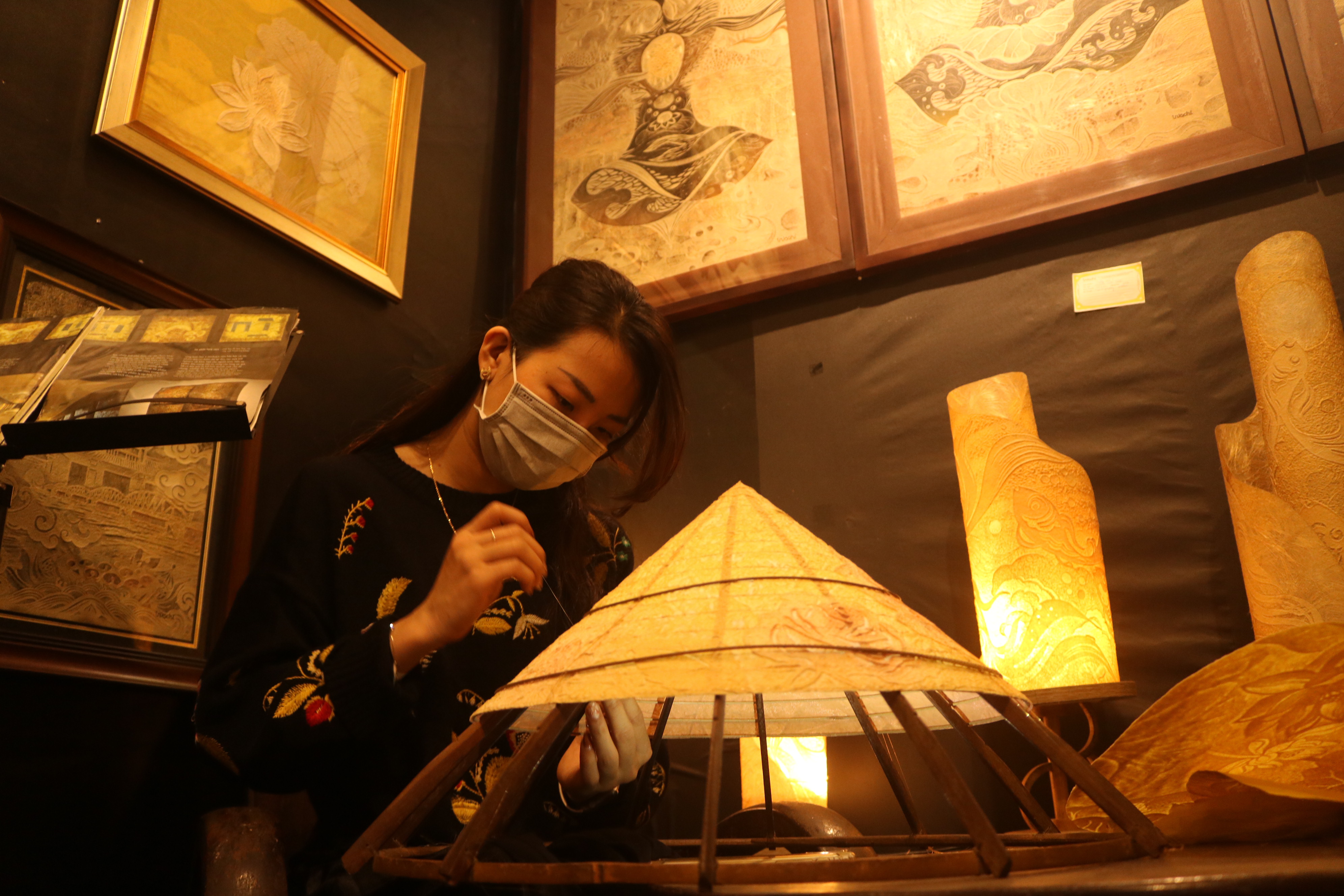 Artist Nguyen Thi Thuy Dung works on a trucchigraphic non la (Vietnamese conical hat) at Truc Chi Garden in Hue. Photo: Hoang An / Tuoi Tre News
