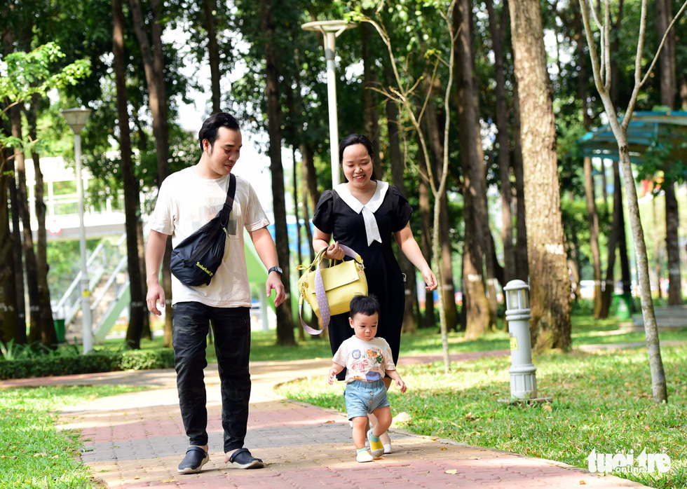Tran Van An, Bui Thi Hoai Thu and their one-year-old child are having a great time together in a park.