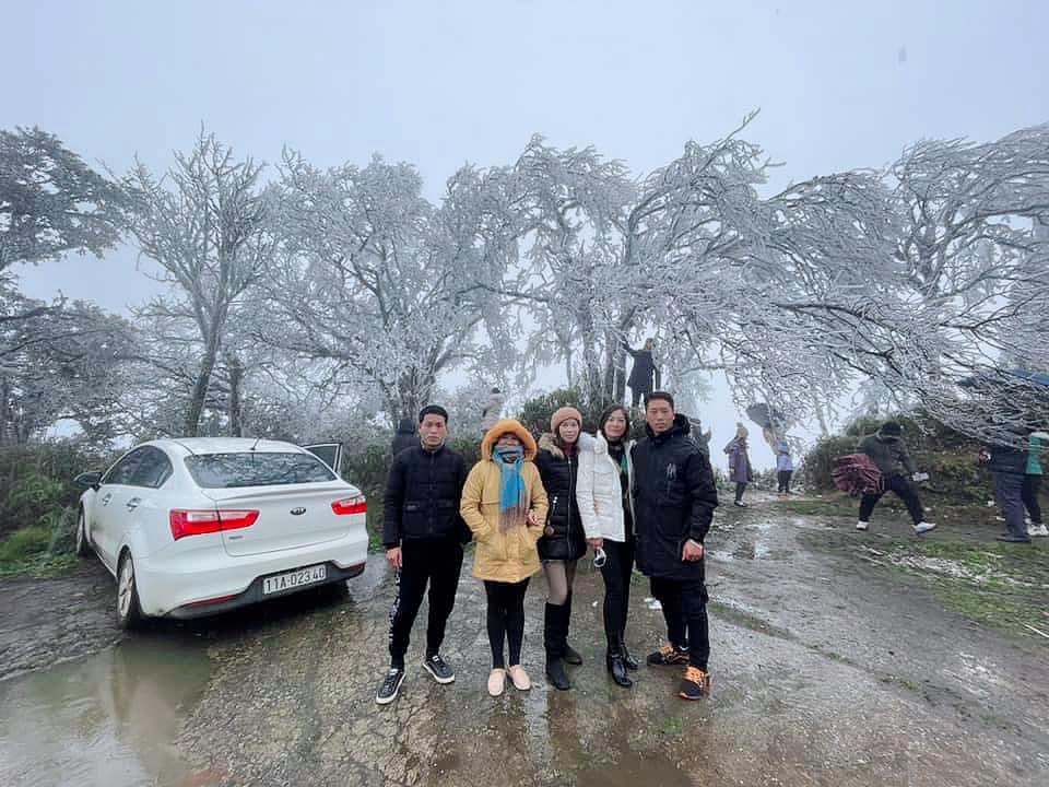 Tourists pose for a photo with frost-covered trees on Phja Oac Mountain in Cao Bang Province, Vietnam, February 21, 2022. Photo: Ha Vi / Tuoi Tre
