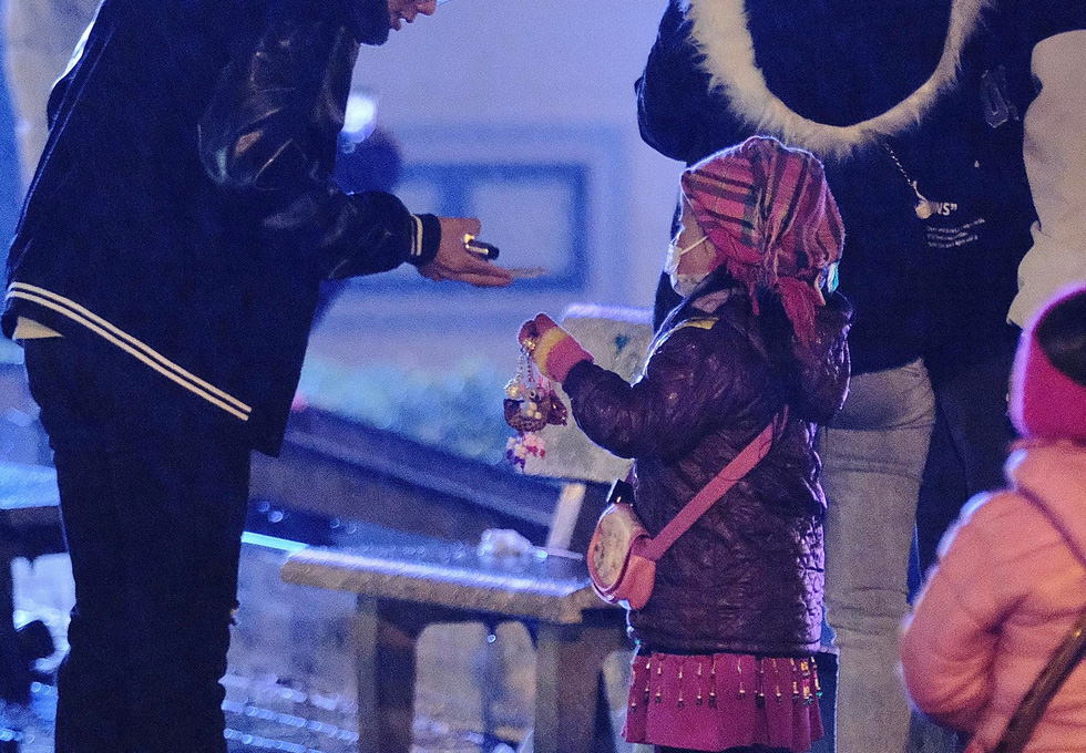 A little girl hawker is seen dealing with her customer in the chilling cold of Sa Pa Town in this image.