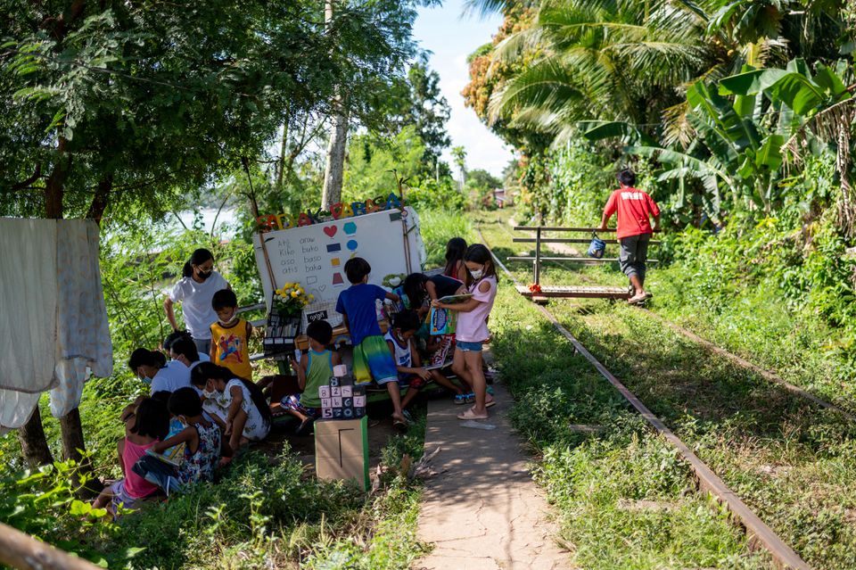 Student volunteers teach children through their makeshift trolley which serves as a mobile library, near the railroad, in Tagkawayan, Quezon Province, Philippines, February 15, 2022. Photo: Reuters