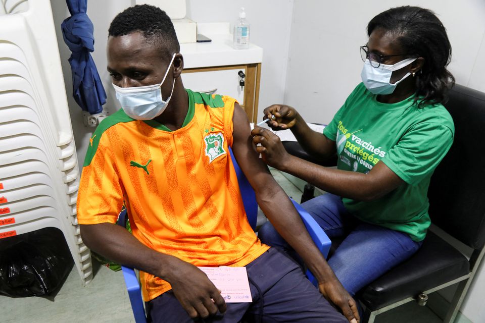 An Ivory Coast fan receives the vaccine against coronavirus disease (COVID -19) at a vaccination center, before watching the Africa Cup of Nations soccer match between Equatorial Guinea and Ivory Coast on a big screen in Abidjan, Ivory Coast January 12, 2022. Photo: Reuters