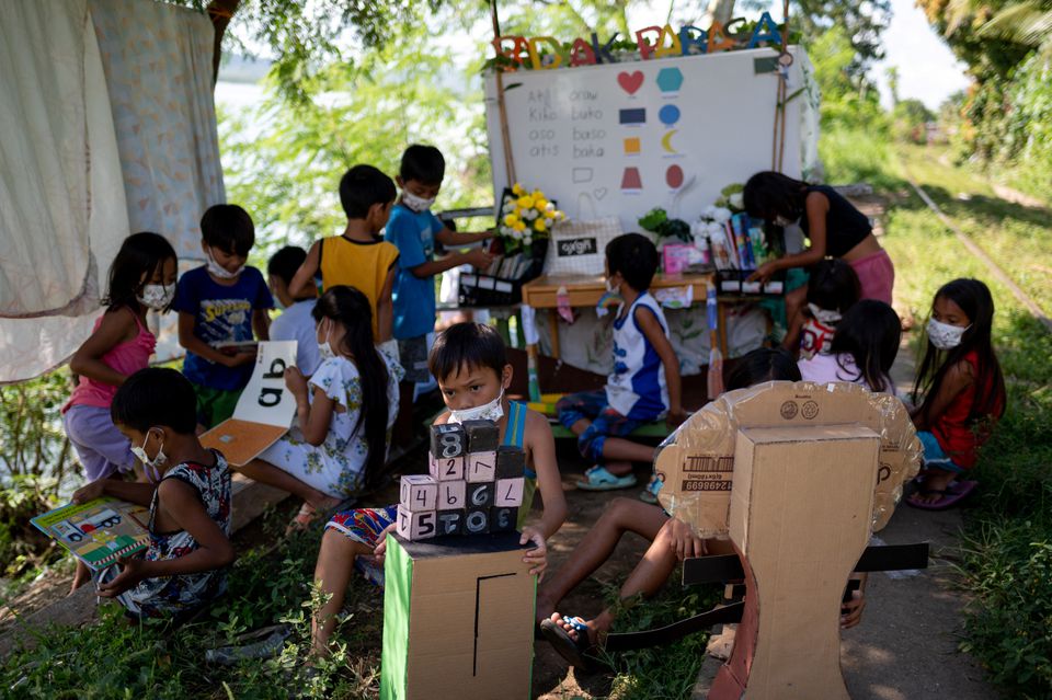 Children read and learn through the makeshift trolley which serves as a mobile library, near the railroad, in Tagkawayan, Quezon Province, Philippines, February 15, 2022. Photo: Reuters