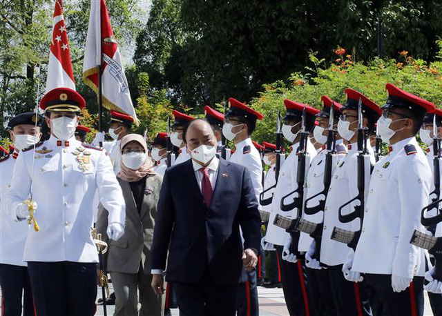 Vietnamese State President Nguyen Xuan Phuc and Singaporean President Halimah Yacob review the guard of honor at The Istana, Singapore, February 25, 2022. Photo: Vietnam News Agency