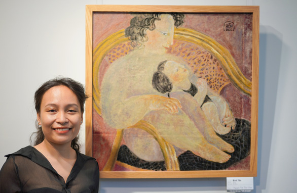 Nguyen Thi Thu Hien and her painting ‘Binh Yen’ (Peace). As a mom, her favorite thing to dos is watching her baby sleep safely in her arms, as depicted in the painting.