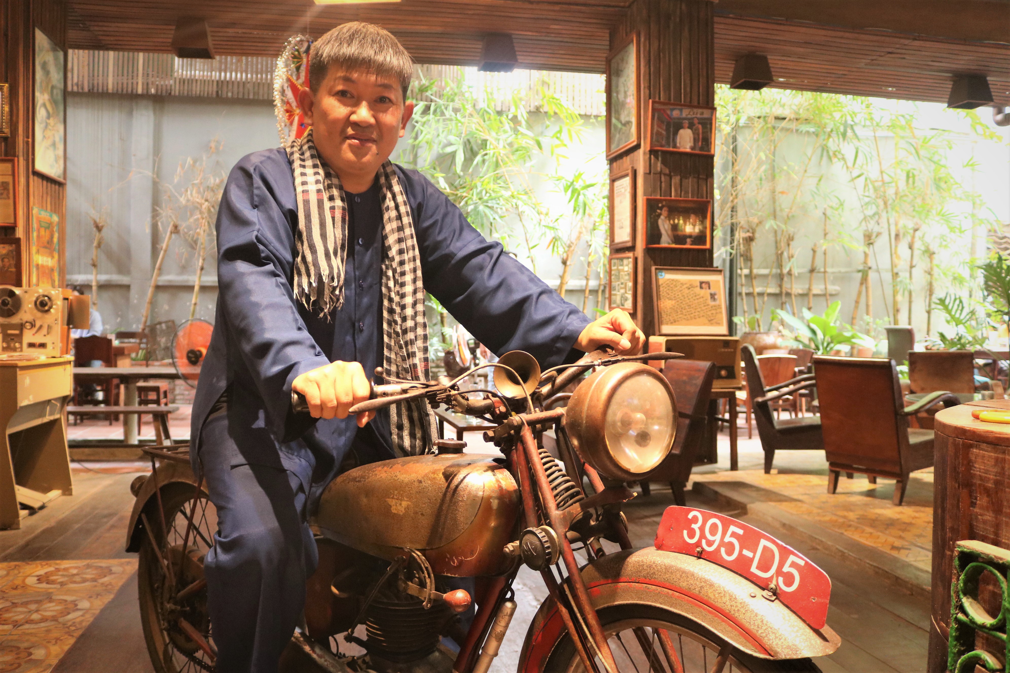 Huynh Minh Hiep, the owner of Lua Saigon café, poses with his 1938 Motobecane AB1 at Lua Sai Gon café in Phu Nhuan District, Ho Chi Minh City. Photo: Hoang An / Tuoi Tre News