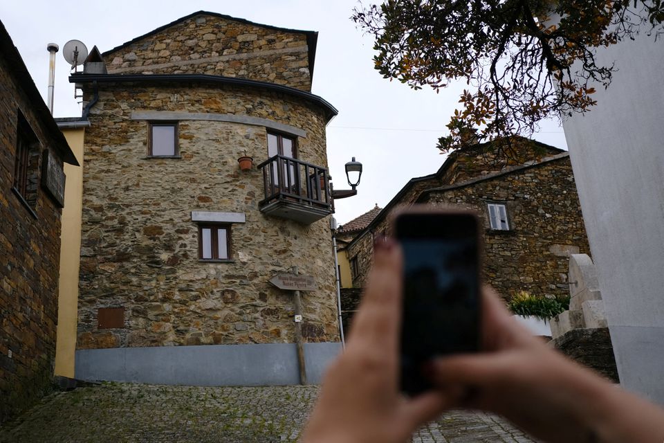 A person takes a photo at the schist village of Fajao, Pampilhosa da Serra , Portugal, February 24, 2022. Photo: Reuters