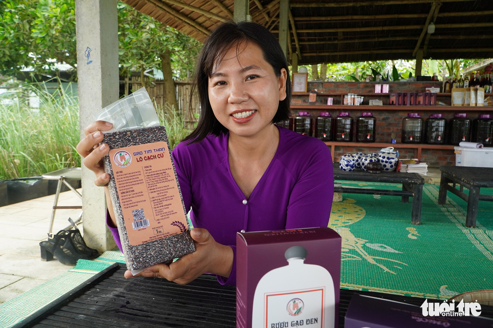 Nga holds a bag of black rice from Lo gach cu, which is certified with a three-star OCOP quality standard. Photo: Le Trung / Tuoi Tre