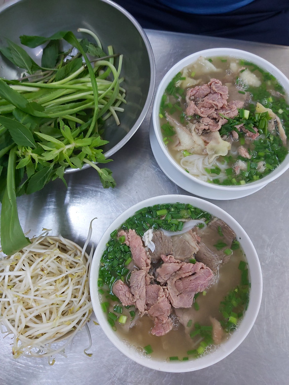 An illustration shows two bowls of 'pho' served with herbs and bean sprouts. Photo: Nhu Binh / Tuoi Tre