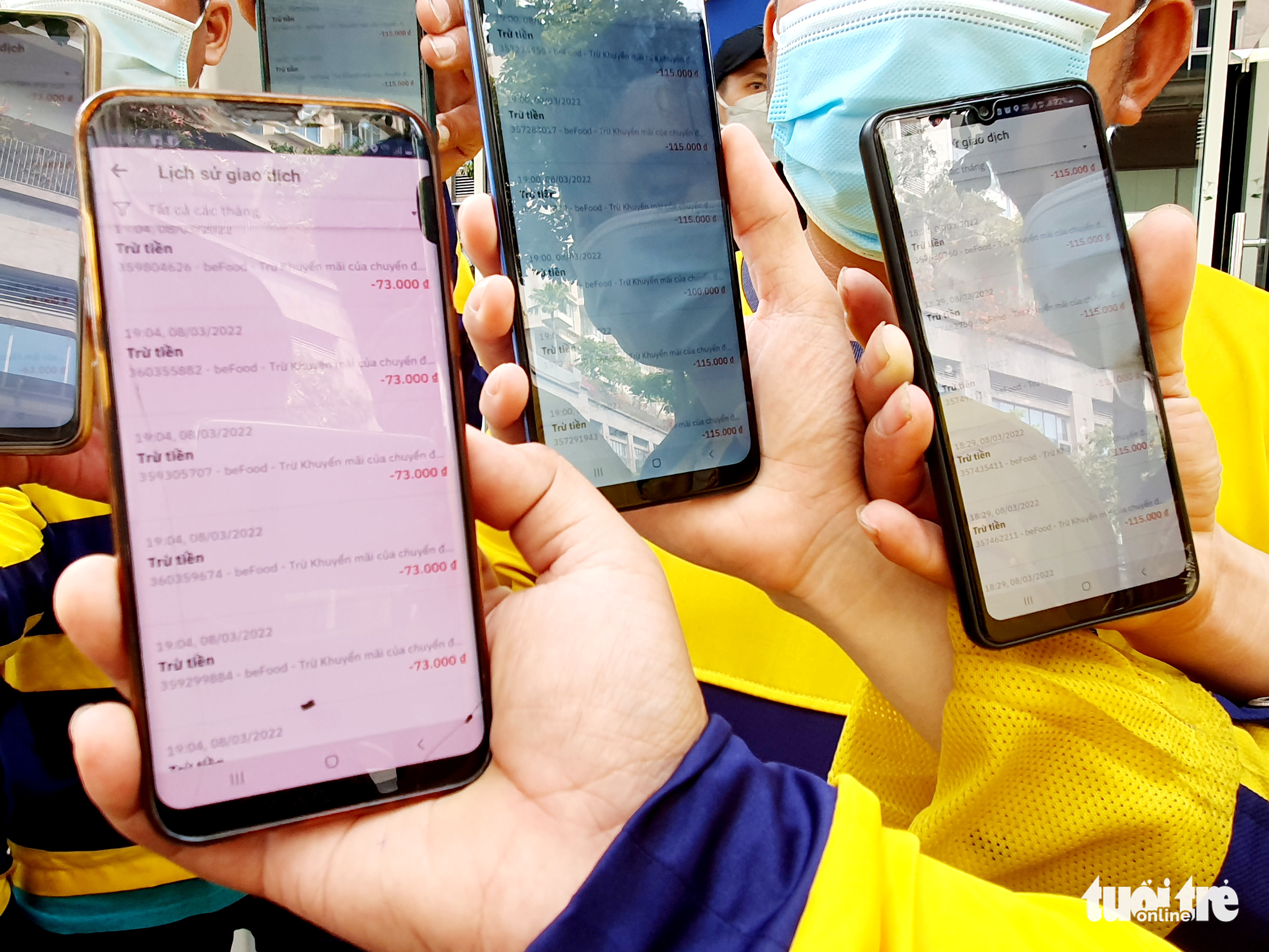 Food delivery partners show notifications of deductions on their partnership account balance in front of Be Group’s headquarters in Thu Duc City, Ho Chi Minh City, March 9, 2022. Photo: Cong Trung / Tuoi Tre