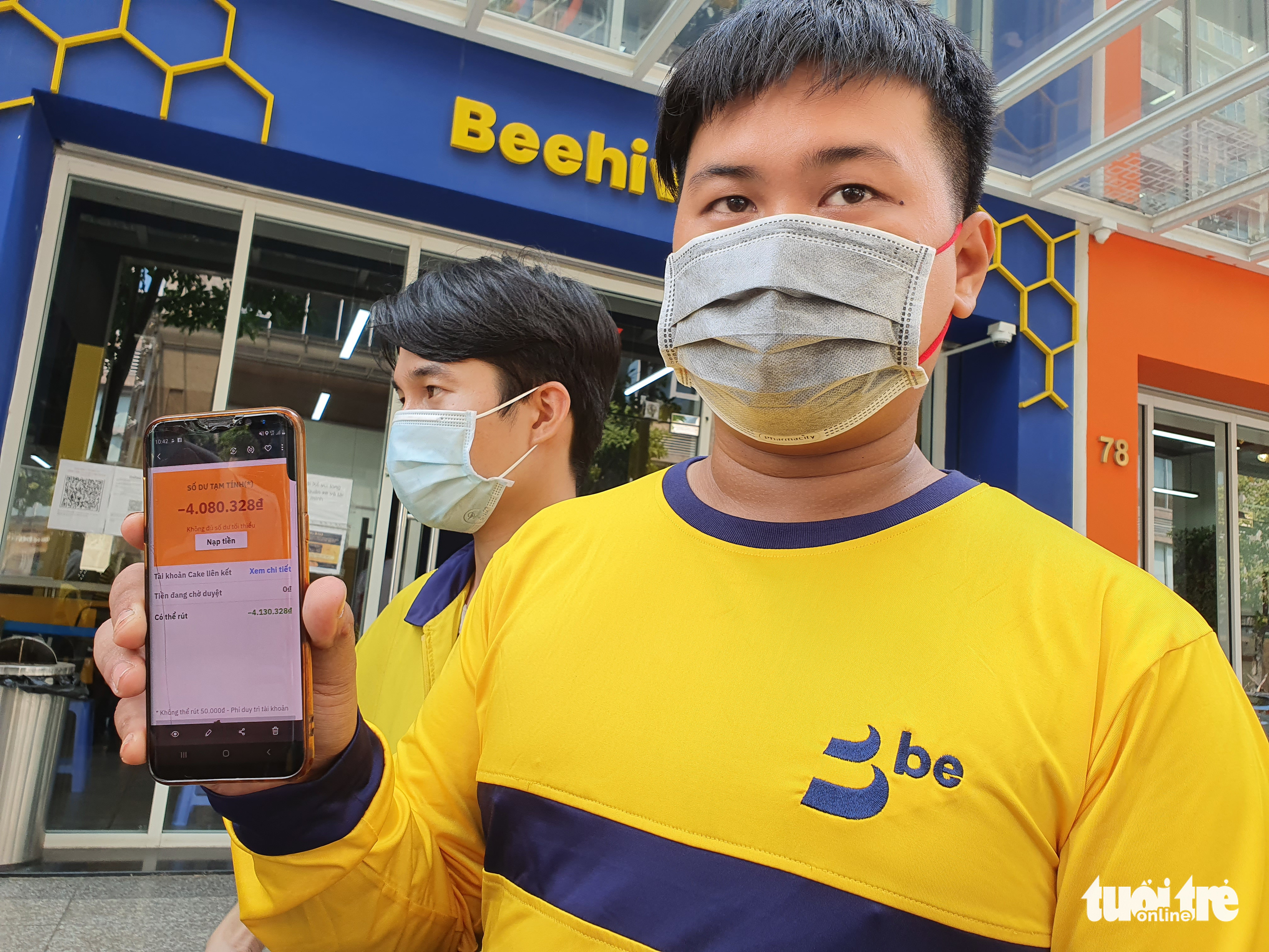 A food delivery partner shows his negative partnership account balance in front of Be Group’s headquarters in Thu Duc City, Ho Chi Minh City, March 9, 2022. Photo: Cong Trung / Tuoi Tre