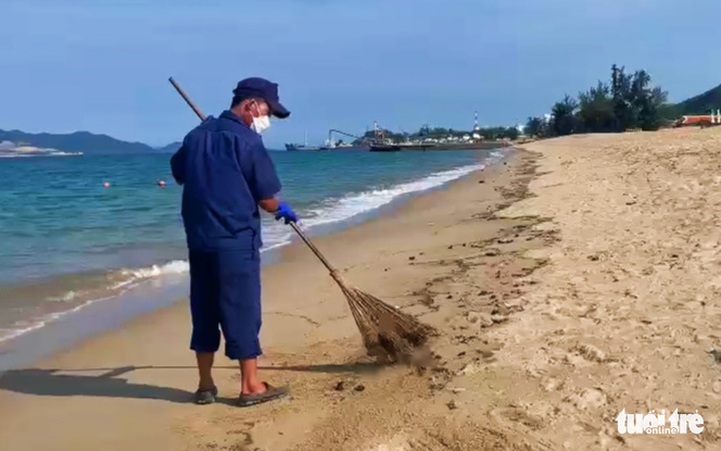 An environmental worker cleans crude oil masses of unknown origins on a beach in Nha Trang City, Khanh Hoa Province, Vietnam, March 17, 2022. Photo: Minh Chien / Tuoi Tre