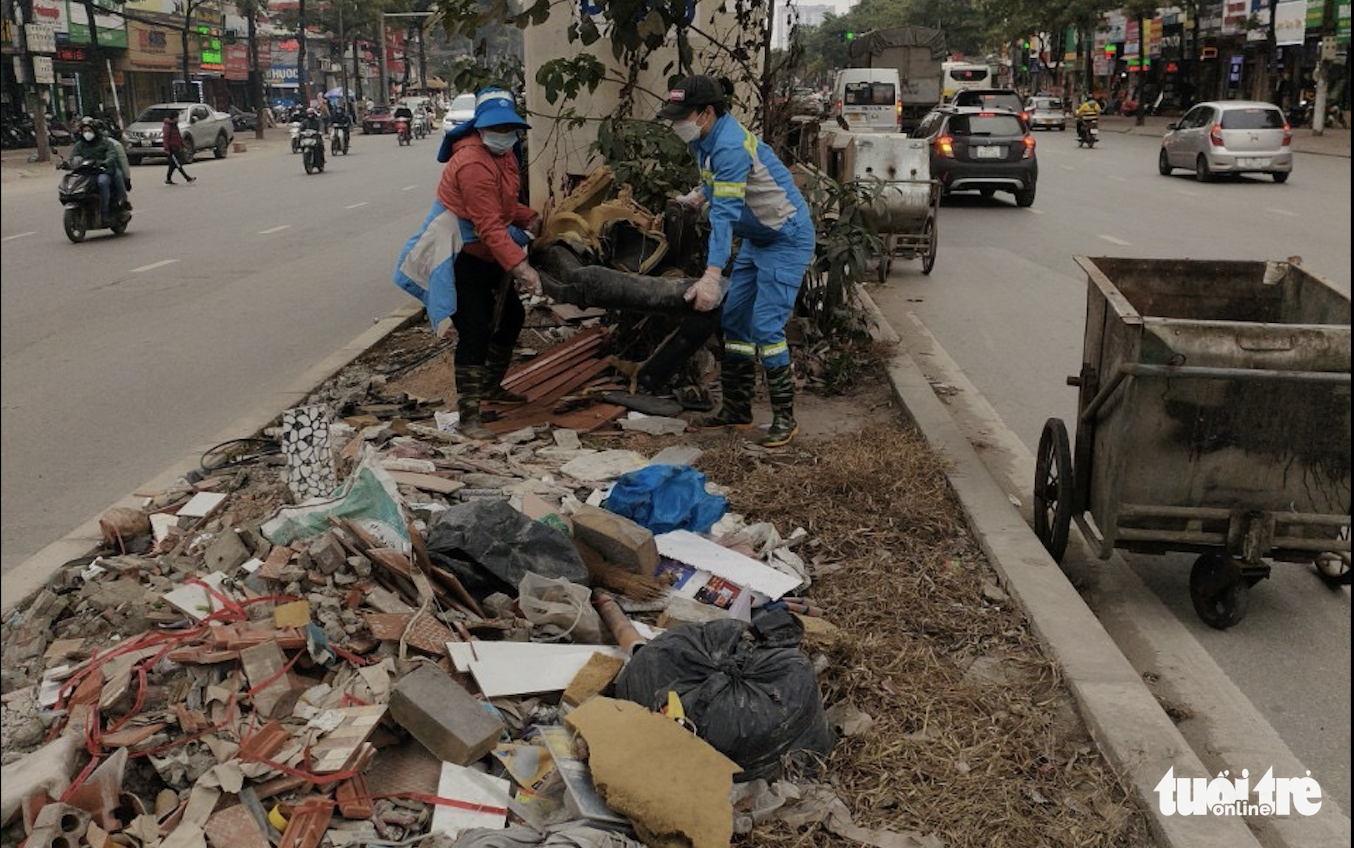 Environmental workers clean up garbage along Ho Tung Mau Street in Nam Tu Liem District, Hanoi, March 19, 2022. Photo: Anh Tuyet / Tuoi Tre