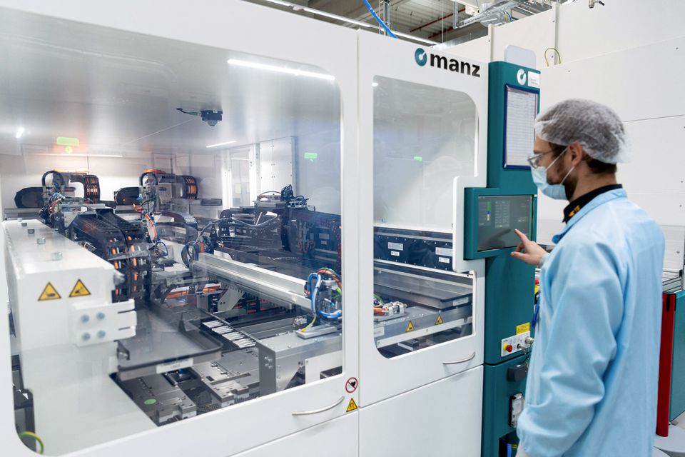 An employee poses at a machine in a clean room at TE Connectivity in Woerth, Germany, February 16, 2022. Photo: Reuters