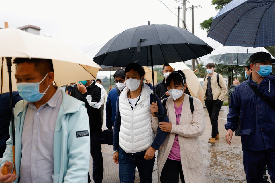 People, some of who are believed to be relatives of victims, walk near the entrance of Lu village near the site where a China Eastern Airlines Boeing 737-800 plane flying from Kunming to Guangzhou crashed, in Wuzhou, Guangxi Zhuang Autonomous Region, China March 23, 2022. Photo: REUTERS