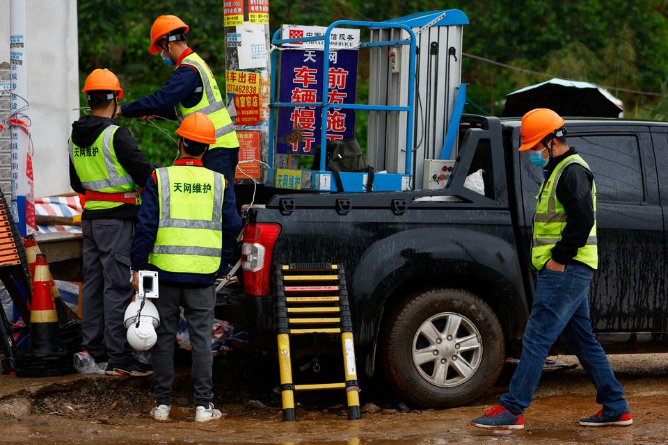 Workers install security cameras at the entrance of Lu village near the site where a China Eastern Airlines Boeing 737-800 plane flying from Kunming to Guangzhou crashed, in Wuzhou, Guangxi Zhuang Autonomous Region, China March 23, 2022. Photo: REUTERS