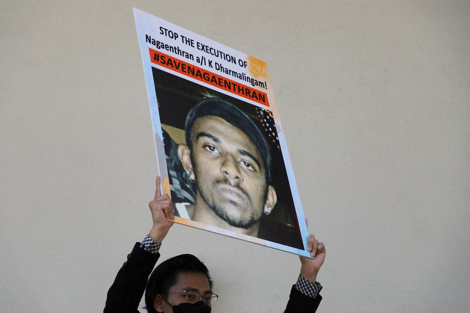 An activist holds a poster against the execution of Nagaenthran Dharmalingam, a Malaysian whose intellect, his defence and human rights groups have argued, was at a level recognised as a mental disability, for drug trafficking in Singapore, as activists submit a clemency petition at the Singapore High Commission in Kuala Lumpur, Malaysia, March 9, 2022.  Photo: Reuters