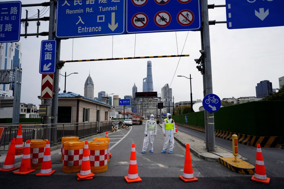 Police officers in protective suits keep watch at an entrance to a tunnel leading to the Pudong area across the Huangpu river, after traffic restrictions amid the lockdown to contain the spread of the coronavirus disease (COVID-19) in Shanghai, China March 28, 2022. Photo: Reuters