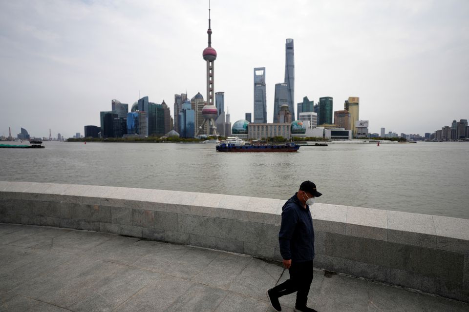 A man walks past Lujiazui financial district, seen across the Huangpu river, amid the lockdown in Pudong area to contain the spread of the coronavirus disease (COVID-19) in Shanghai, China March 28, 2022. Photo: Reuters