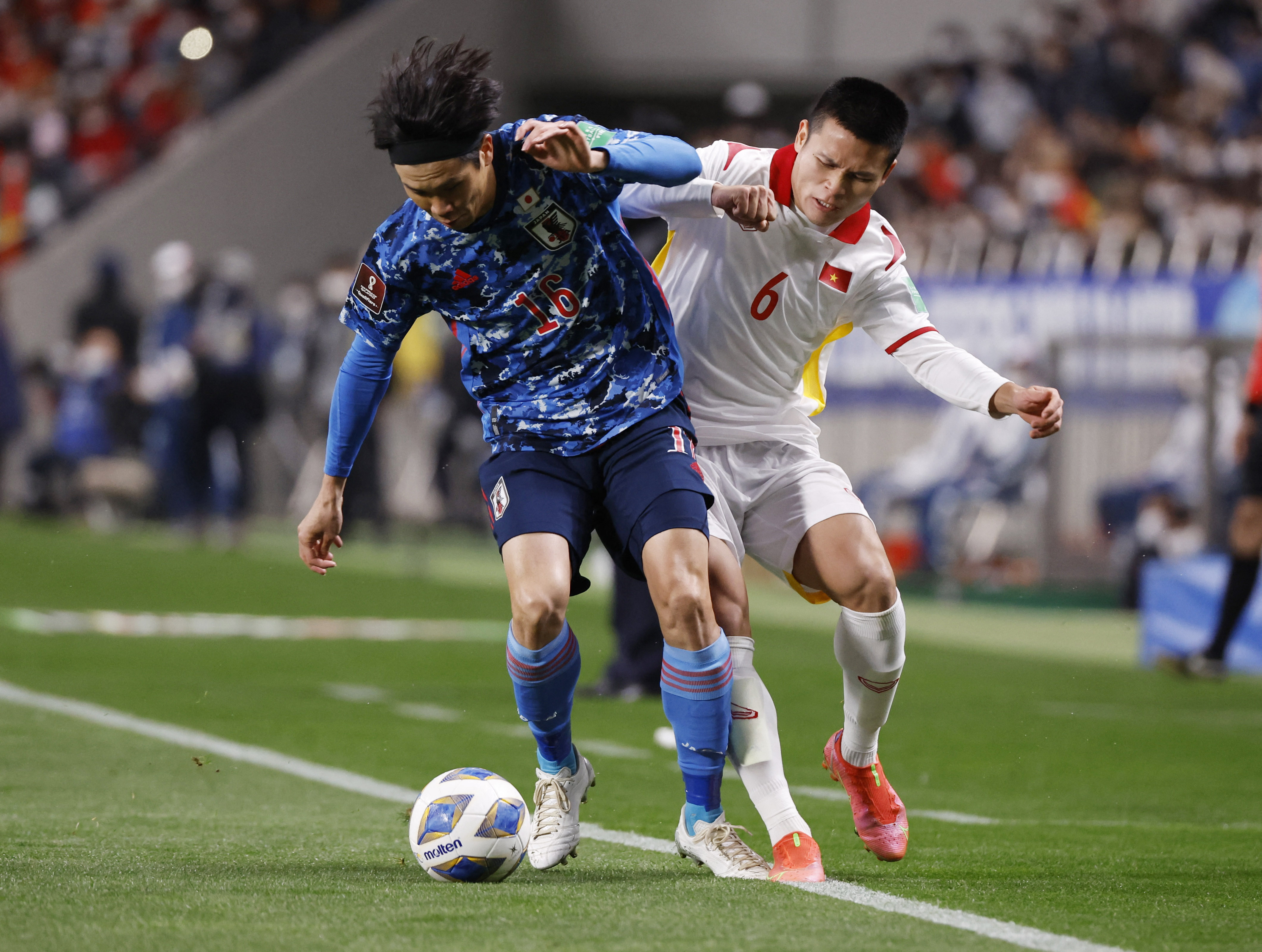 Vietnamese (white jersey) and Japanese players vie for the ball in their last game of the 2022 FIFA World Cup Asian qualifiers at Saitama Stadium, March 29, 2022. Photo: Reuters