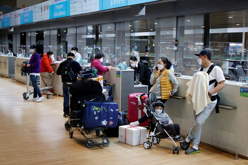 People wearing face masks to prevent from contracting the coronavirus disease (COVID-19) wait to check in at Incheon International Airport, in Incheon, South Korea, March 25, 2022. Picture taken March 25, 2022. Photo: Reuters