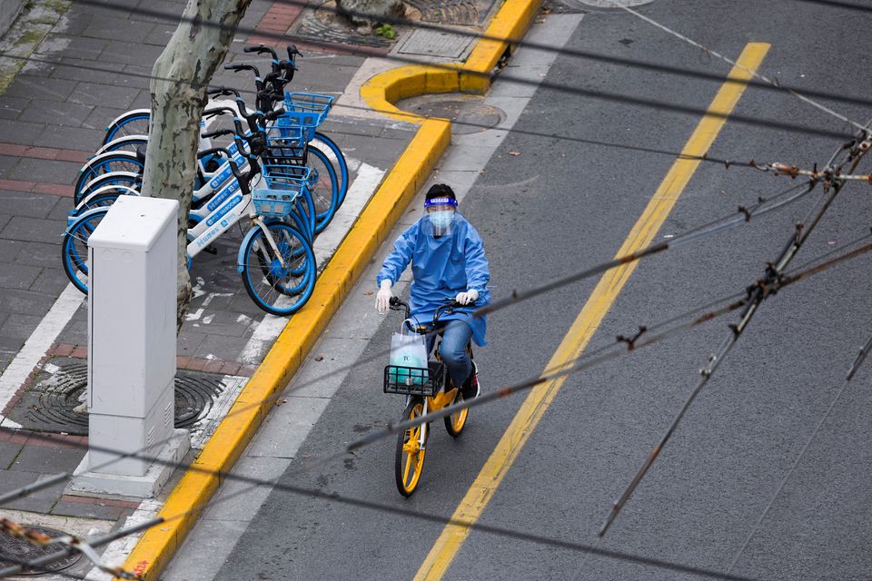 A woman in personal protective equipment (PPE) rides a bicycle on a street, during the lockdown to curb the spread of the coronavirus disease (COVID-19) in Shanghai, China, April 5, 2022. Photo: Reuters