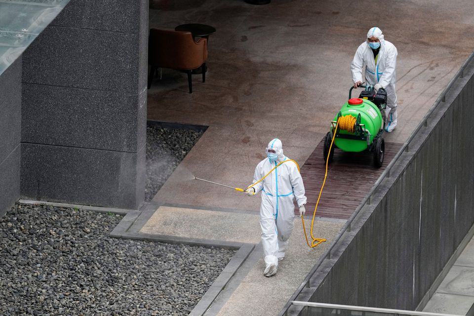 Workers in protective suit spray disinfectant at a community, during the lockdown to curb the spread of the coronavirus disease (COVID-19) in Shanghai, China, April 5, 2022. Photo: Reuters