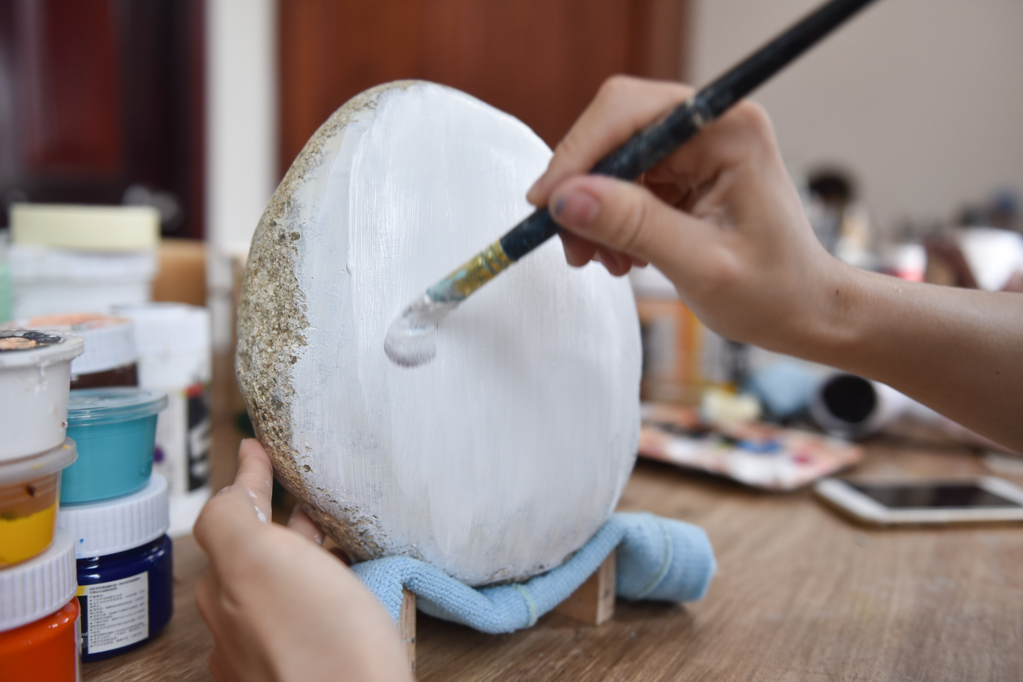 An artist is working on a pebble’s surface before painting on it. Photo: Ngoc Phuong / Tuoi Tre