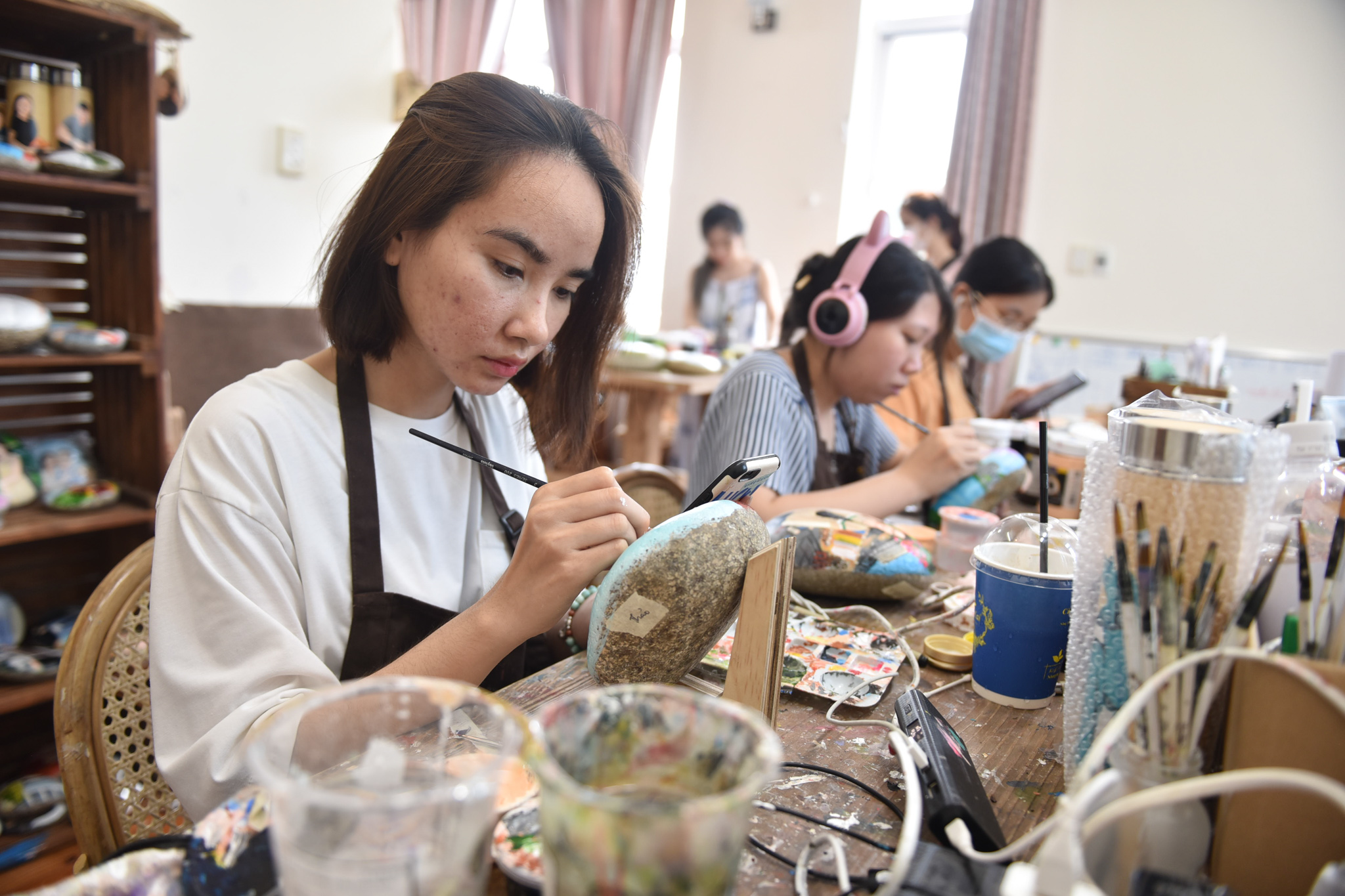 Artists are working on pebble paintings at Sỏi Nghệ Thuật - G.Art at Thao Dien Ward, Thu Duc City Ho Chi Minh City. Photo: Ngoc Phuong / Tuoi Tre