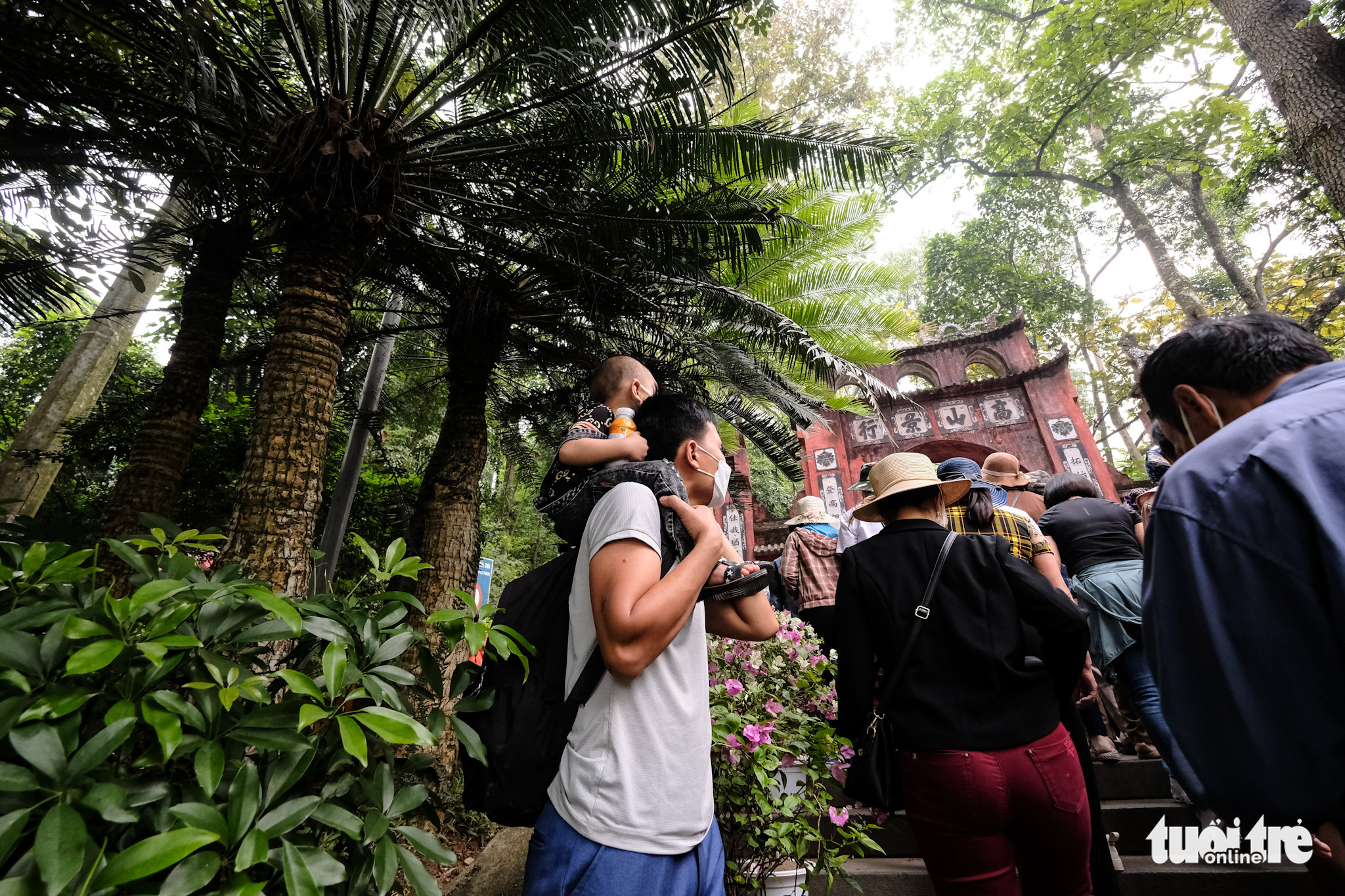 A man carries his child to the Hung King Temples in Phu Tho Province, Vietnam, April 10, 2022. Photo: Nam Tran / Tuoi Tre