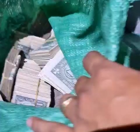 The stolen cash is confiscated by police officers in this supplied photo.