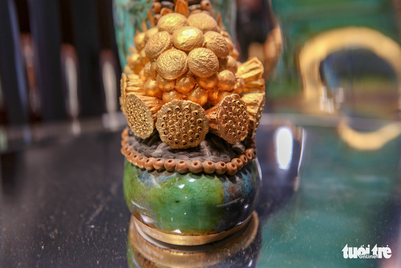 A ceramic boot in emerald green is adorned with a lacquer-coated lotus seed head pattern. Photo: Ha Quan / Tuoi Tre