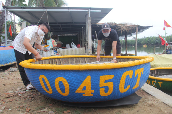 Villagers give their basket boats a facelift to welcome back tourists after the COVID-19 pandemic. Photo: Truong Trung / Tuoi Tre